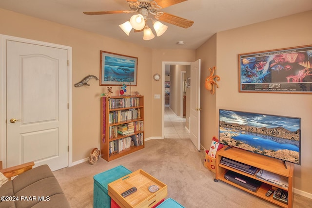 living area featuring light colored carpet and ceiling fan