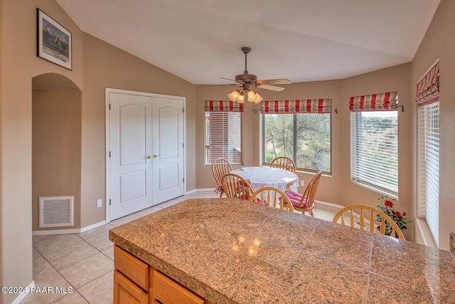 dining room featuring vaulted ceiling, ceiling fan, and light tile patterned flooring