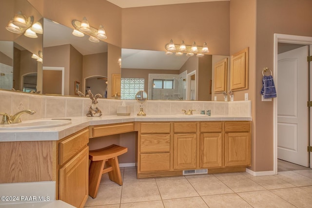 bathroom featuring backsplash, tile patterned flooring, vanity, and lofted ceiling