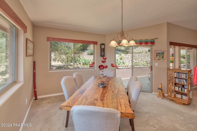 carpeted dining area with an inviting chandelier