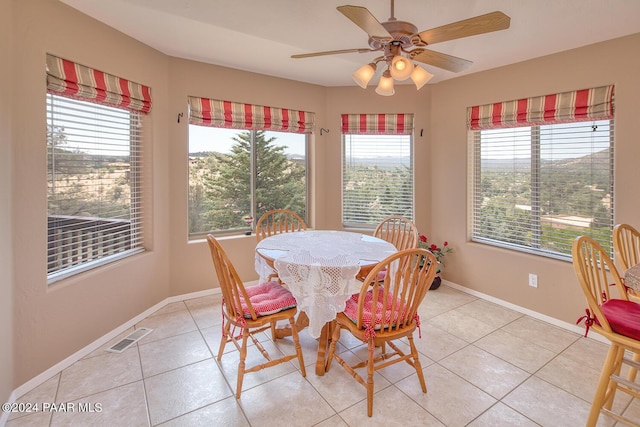 tiled dining space featuring ceiling fan and a healthy amount of sunlight