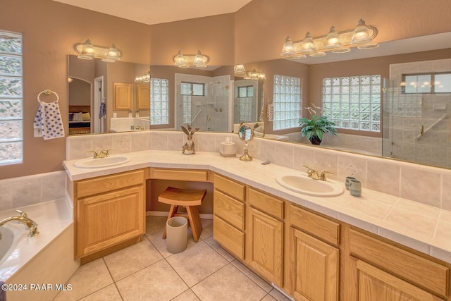 bathroom featuring tile patterned flooring, vanity, and separate shower and tub