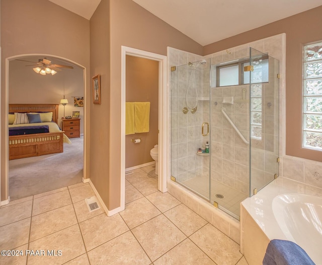 bathroom with vaulted ceiling, tile patterned flooring, ceiling fan, separate shower and tub, and toilet