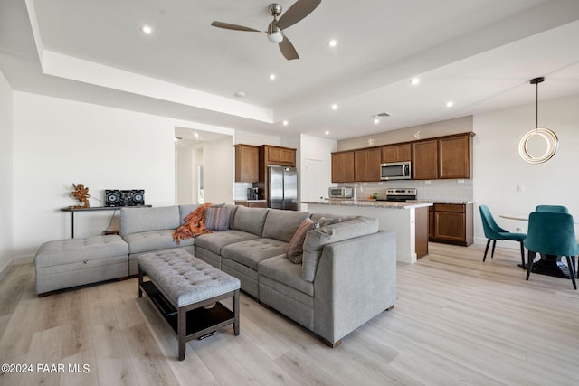 living room featuring ceiling fan and light hardwood / wood-style flooring