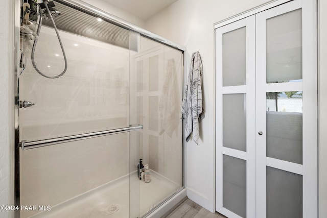 bathroom featuring hardwood / wood-style floors and a shower with shower door