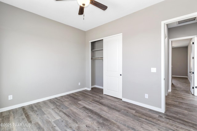 unfurnished bedroom with ceiling fan, dark hardwood / wood-style flooring, and a closet