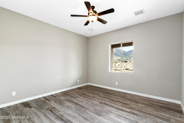 spare room featuring dark hardwood / wood-style flooring and ceiling fan