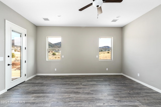 spare room with visible vents, baseboards, ceiling fan, and dark wood-style flooring