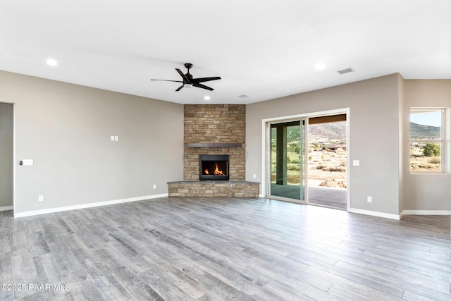 unfurnished living room featuring ceiling fan, light hardwood / wood-style floors, and a fireplace