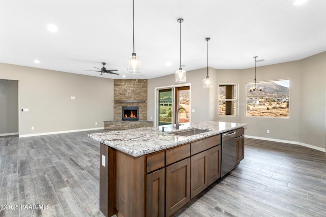 kitchen with stainless steel dishwasher, ceiling fan with notable chandelier, sink, and hanging light fixtures