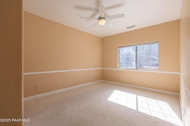 unfurnished room with visible vents, a ceiling fan, baseboards, and carpet floors