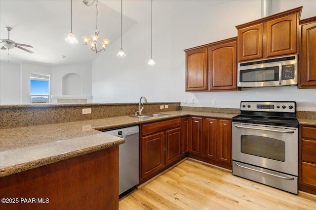 532 Goshawk Trl, Prescott, AZ 86301 - kitchen with appliances with stainless steel finishes, light wood finished floors, ceiling fan, hanging light fixtures, and stone counters