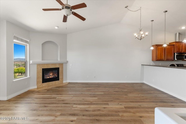 532 Goshawk Trl, Prescott, AZ 86301 - unfurnished living room with a fireplace, light wood-type flooring, a ceiling fan, a chandelier, and lofted ceiling