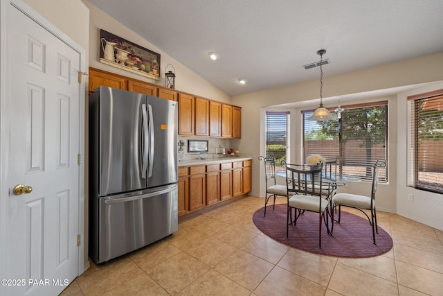 4034 N Sheridan Ln, Prescott Valley, AZ 86314 - kitchen featuring freestanding refrigerator, brown cabinets, lofted ceiling, light countertops, and plenty of natural light