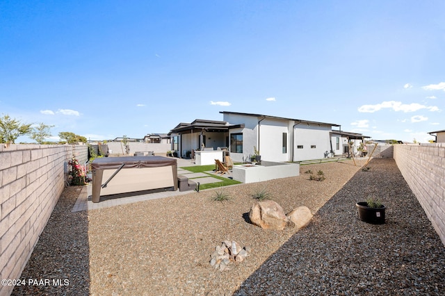 back of house with a patio area and a hot tub