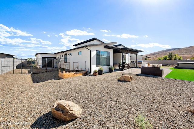 back of property with a patio area, an outdoor living space, and a mountain view