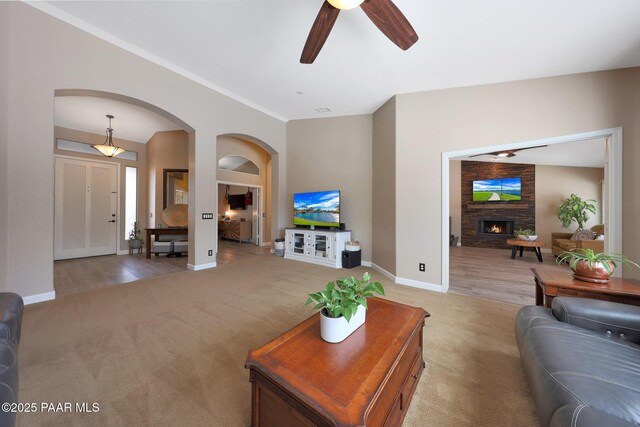 26647 N 43rd St, Cave Creek, AZ 85331 - living room featuring light colored carpet, arched walkways, a ceiling fan, and a stone fireplace
