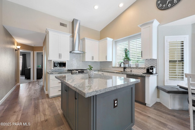 26647 N 43rd St, Cave Creek, AZ 85331 - kitchen featuring wall chimney range hood, stainless steel appliances, decorative backsplash, light wood-style flooring, and lofted ceiling