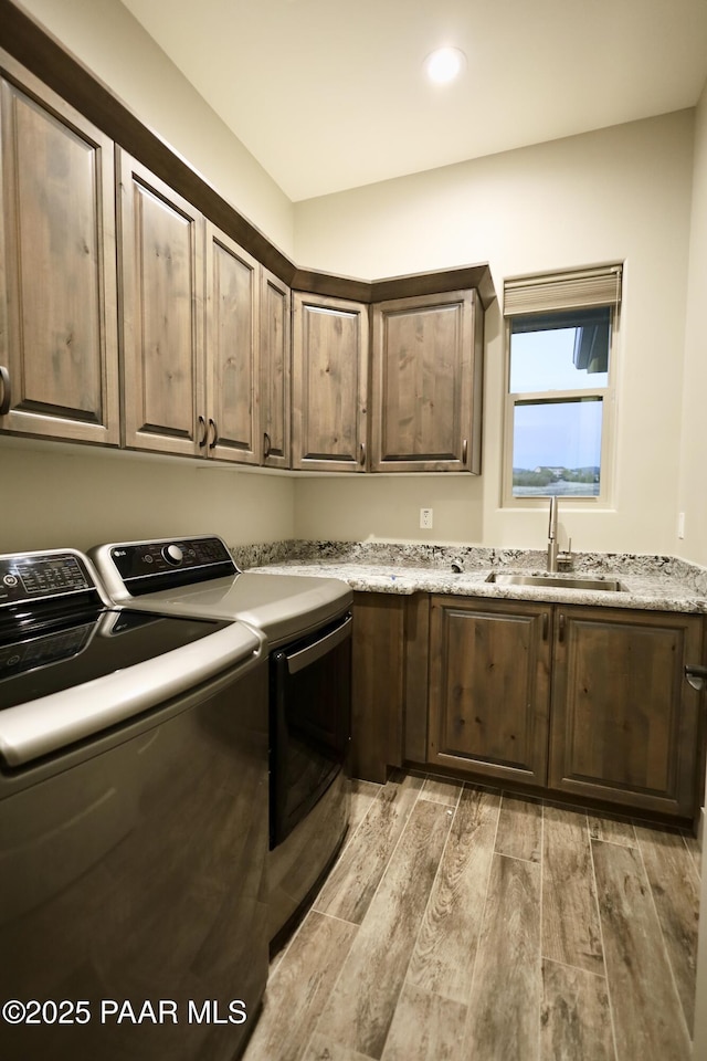 9192 N Doc Bar Rd, Prescott Valley, AZ 86315 - washroom with washing machine and clothes dryer, cabinet space, light wood-type flooring, and recessed lighting