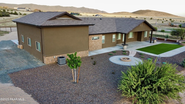 9192 N Doc Bar Rd, Prescott Valley, AZ 86315 - view of side of home with a mountain view, a patio area, roof with shingles, and an outdoor fire pit