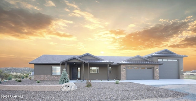 9192 N Doc Bar Rd, Prescott Valley, AZ 86315 - view of front of home with stone siding, an attached garage, a standing seam roof, driveway, and metal roof