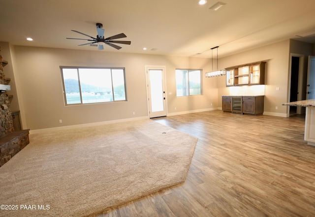 9192 N Doc Bar Rd, Prescott Valley, AZ 86315 - unfurnished living room with recessed lighting, plenty of natural light, ceiling fan, a stone fireplace, and light wood finished floors