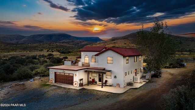 view of front of house featuring a mountain view, a garage, and cooling unit