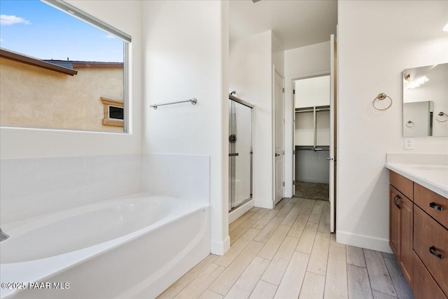 8935 N Tromontana Rd, Prescott Valley, AZ 86315 - bathroom with vanity, a shower stall, wood finished floors, a garden tub, and baseboards