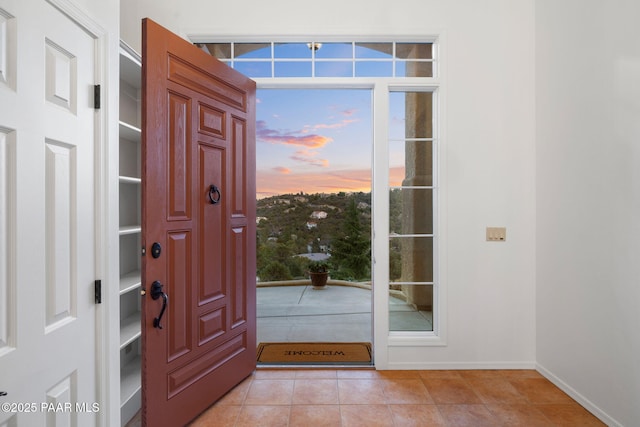 foyer featuring light tile patterned floors and baseboards