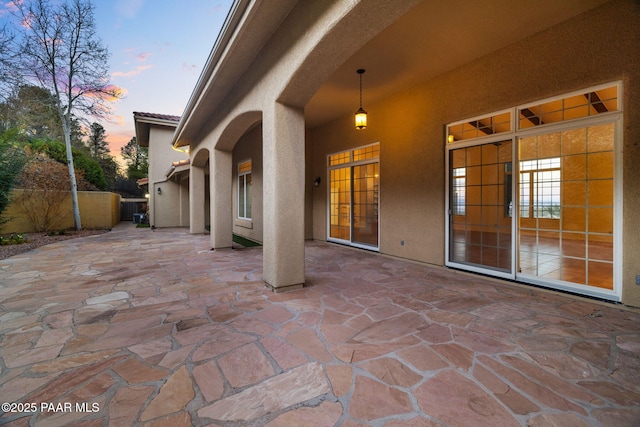 patio terrace at dusk featuring fence