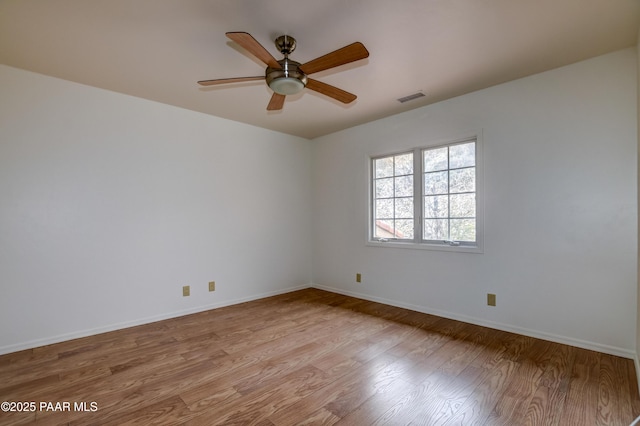 empty room featuring light wood-type flooring, visible vents, baseboards, and a ceiling fan