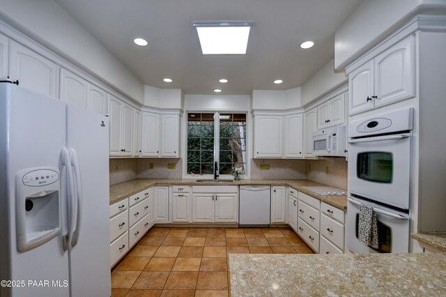 kitchen featuring white appliances, recessed lighting, tasteful backsplash, and a sink