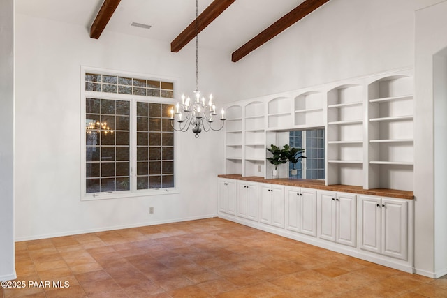 unfurnished dining area with visible vents, baseboards, beamed ceiling, a high ceiling, and a notable chandelier