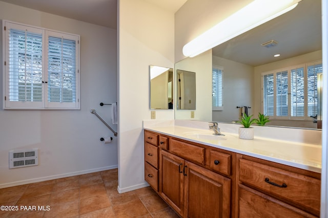 bathroom with visible vents, baseboards, heating unit, and vanity