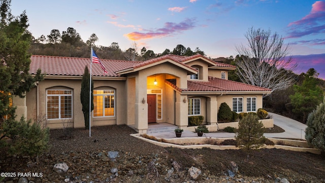 mediterranean / spanish-style house featuring stucco siding and a tile roof