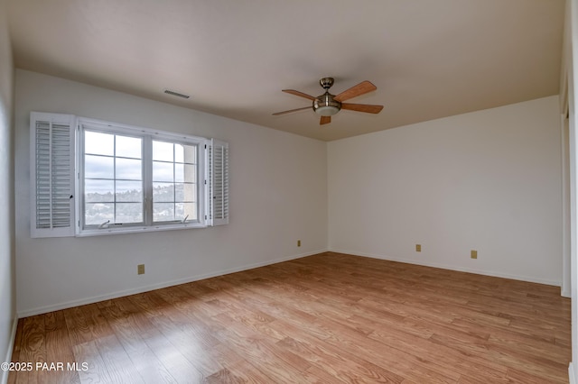 unfurnished room with visible vents, ceiling fan, light wood-type flooring, and baseboards