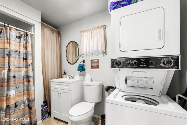 bathroom featuring vanity, stacked washer and dryer, and toilet