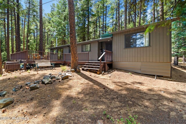 rear view of house featuring a wooden deck