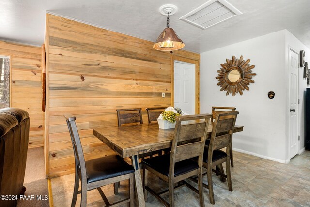 dining space featuring wooden walls