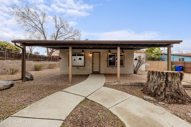 view of front of house with concrete block siding and fence