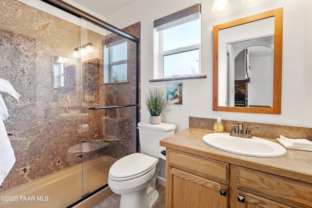 bathroom with vanity, toilet, and a shower with shower door