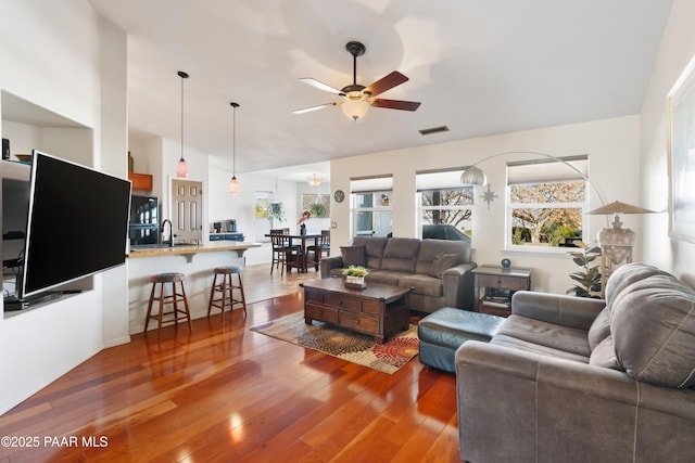 living room with dark hardwood / wood-style flooring, sink, and ceiling fan
