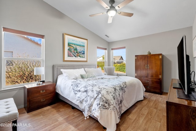 bedroom with ceiling fan, light hardwood / wood-style floors, and vaulted ceiling