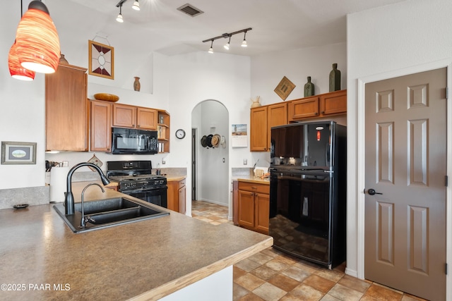 kitchen featuring pendant lighting, sink, rail lighting, high vaulted ceiling, and black appliances