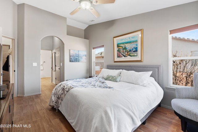 bedroom with connected bathroom, hardwood / wood-style floors, vaulted ceiling, and ceiling fan
