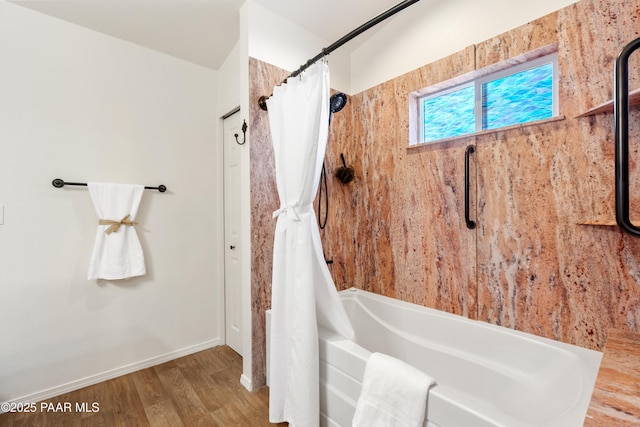 bathroom with wood-type flooring and shower / bath combo with shower curtain