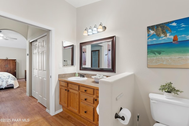 bathroom with ceiling fan, wood-type flooring, toilet, and vanity