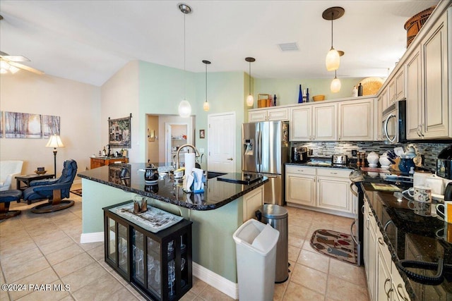 kitchen featuring cream cabinetry, ceiling fan, an island with sink, and appliances with stainless steel finishes