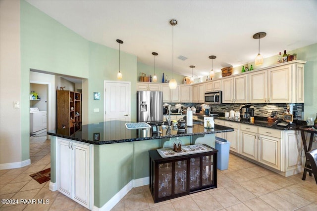 kitchen with pendant lighting, a kitchen island, stainless steel appliances, and washer / dryer