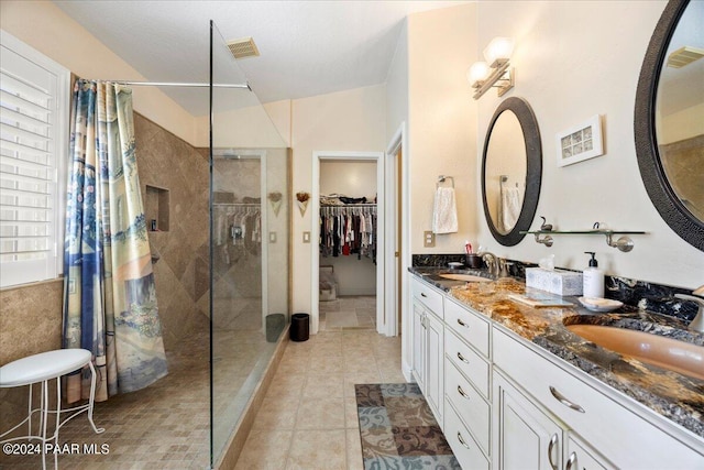 bathroom featuring tile patterned flooring, vanity, and walk in shower